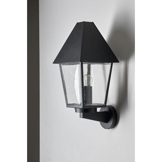 This wall-mounted lantern is produced by Bega as part of their Boom collection, manufactured in Germany. The fixture...