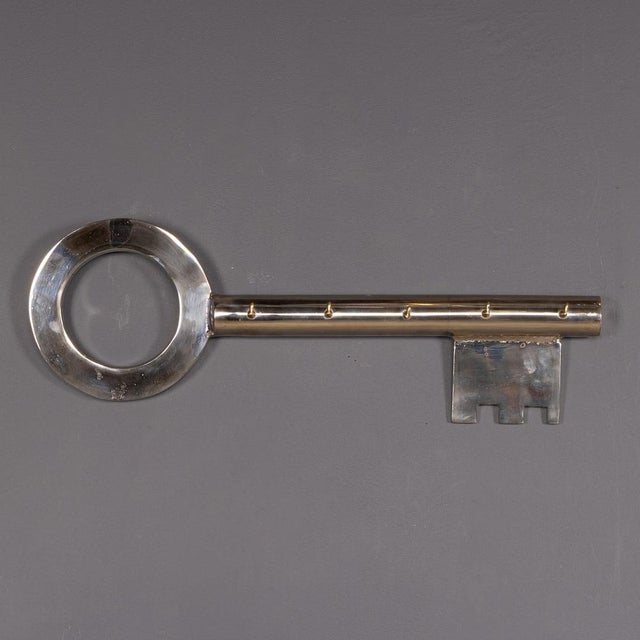 A vintage 20th Century English white metal display key from an English locksmith’s shop, fitted with small brass hooks for...