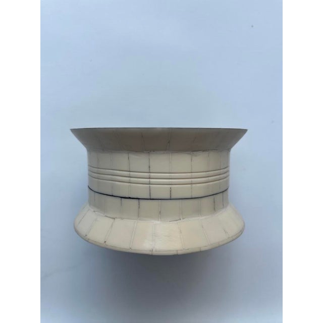 A single round spool shaped trinket box with lid featuring inlaid bone decoration. Interior 2" depth.
