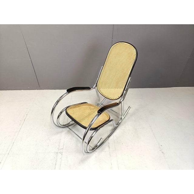 Mid century rocking chair made from chromed metal, rattan woven seats and backrest and lacquered wood. Good condition....