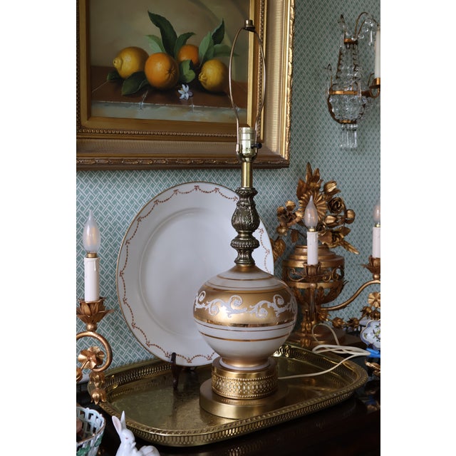 An exceptionally decorative vintage table lamp distinguished by its luminous satin-glass body, layered gilded finishes,...