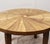 Handcrafted tabletop is a series of triangular segments that radiate from the center in a subtle pinwheell. Each segment...