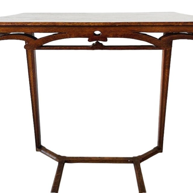 A stunning, elegant, antique Art Nouveau side table made of solid oak. The table's top features carved woodwork with the...