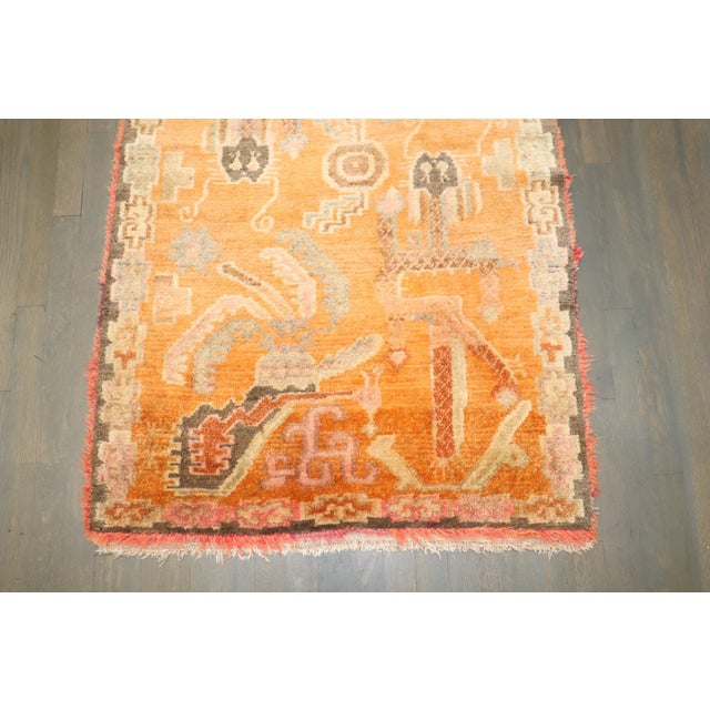 a Colorful one-of-a-kind Tibetan rug from the 2nd quarter of the 20th century with a dragon motif on a bright orange field