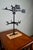 This vintage weathervane features a cast metal horse and buggy motif, mounted on a sturdy oak base for display. The black-...