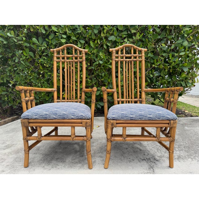 A handsome pair of rattan host chairs featuring elegant pagoda backs, hand-wrapped joinery, and a refined architectural...