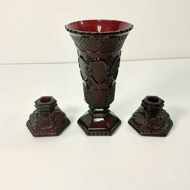 This set is a vibrant Ruby Red Depression Glass Candle Holders and Vase. They feature the Diamond Point design the was...
