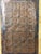 Antique, primitive, hand made wooden cutting board with a copper hand punched sheet of the alphabet attached in the...