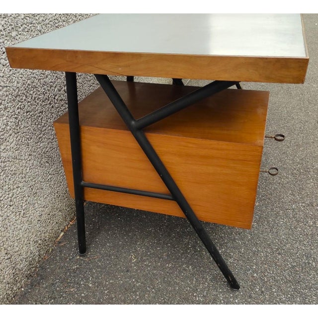 Center desk with a tubular metal frame, two wooden drawers, and a wooden top with Formica on top. An original example of...