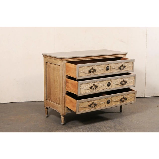 A French carved and bleached oak commode from the 19th century. This antique chest from France has a rectangular-shaped...