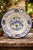 A hand-painted Italian majolica decorative plate by Verdiani Firenze in the “Decoro Arcaico” pattern. The design features...