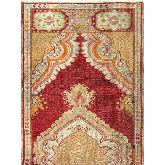 This Mid-20th century Turkish Oushak rug, measuring 1' 11" x 4' 11", features a luminous palette and a graceful...