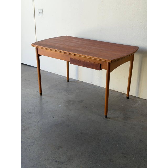 Authentic Mid-Century Modern Danish teak dining table with built-in drawers on both sides, circa 1960s. This beautifully...