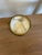 A small footed bowl turned from alabaster, banded in brass at the rim. It stands on its own short pedestal, so it reads...