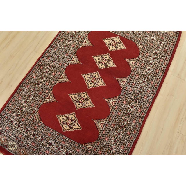 A tribal Bokhara Jaldar rug hand-knotted with fine wool on a cotton foundation. This rug features a row of repeating...