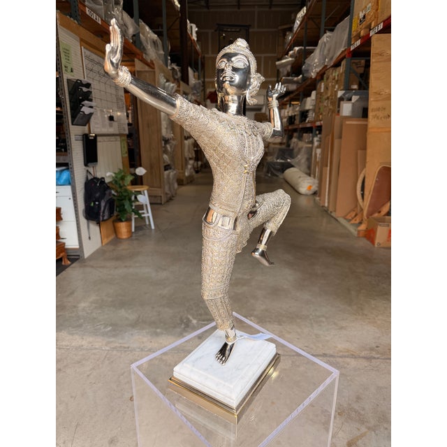Make a bold statement with this contemporary figurative sculpture, featuring a polished nickel-finished brass figure...