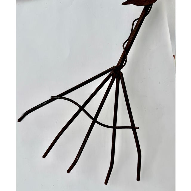A cheerful wrought iron wall-mounted plant holder, probably French, dating to the 20th century. A central spade and two...