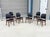 This exceptional set of six mid-century modern dining chairs beautifully pairs warm, teak frames with sleek black vinyl...