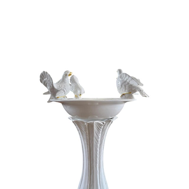A playful Italian majolica birdbath in cream featuring a round basin surrounded by five doves and resting upon a pedestal...