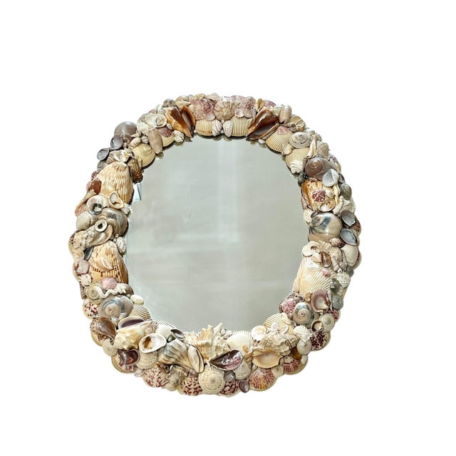Vintage oval shell encrusted mirror. Beautiful variety of colorful shells on a fabric backed mirror board.