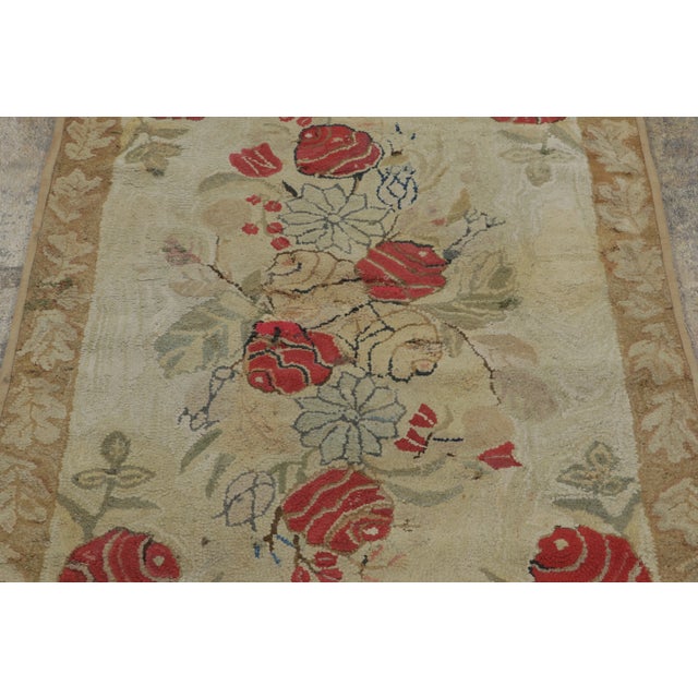 This antique 3x4 hooked rug, circa 1920–1929, features an elegant floral bouquet medallion framed by vivid red roses and...