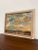 Vintage landscape painting signed '65, featuring a panoramic view of rolling hills beneath a dramatic, cloud-filled sky....