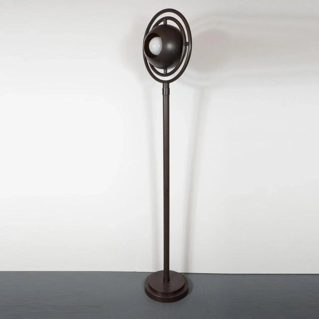Space Age, patinated brass floor lamp with adjustable orbital shade.