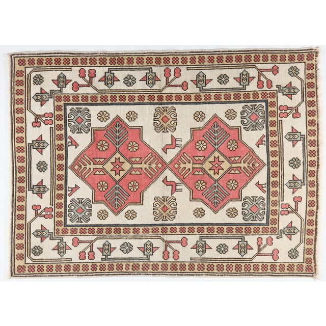 A charming vintage decorative rug featuring a beautifully balanced composition of stylized medallions, symbolic motifs,...