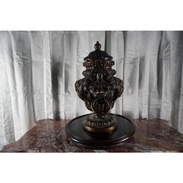 Bring timeless European elegance into your home with this impressive neoclassical urn featuring dramatic lion-head masks...