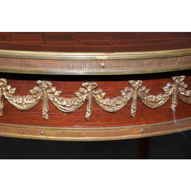 This bronze mounted French Louis XVI center table is an exquisite example of neoclassical craftsmanship, blending...