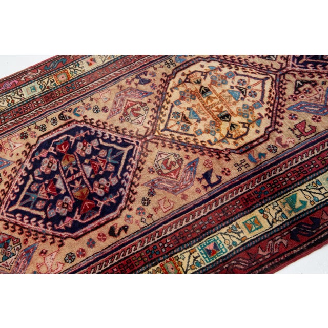 This Vintage Persian Serab wool rug has a light brown color field. This hand-knotted piece features a multicolor tribal...