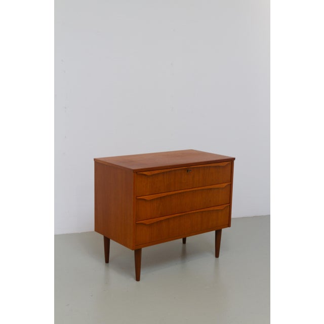 Lovely Scandinavian Mid-Century Modern chest of drawers in teak. Three wide drawers with sculpted pulls in solid teak....
