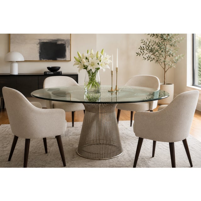 A striking modern dining table inspired by the iconic Warren Platner silhouette, featuring a sculptural wire pedestal base...