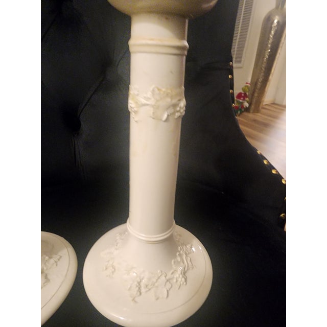 White wedgewood vintage candlesticks with floral design and glossy finish.