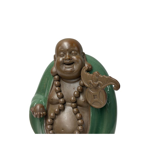 This charming glazed ceramic figurine depicts a joyful, bald Laughing Buddha with a gleaming, smooth brown finish and a...