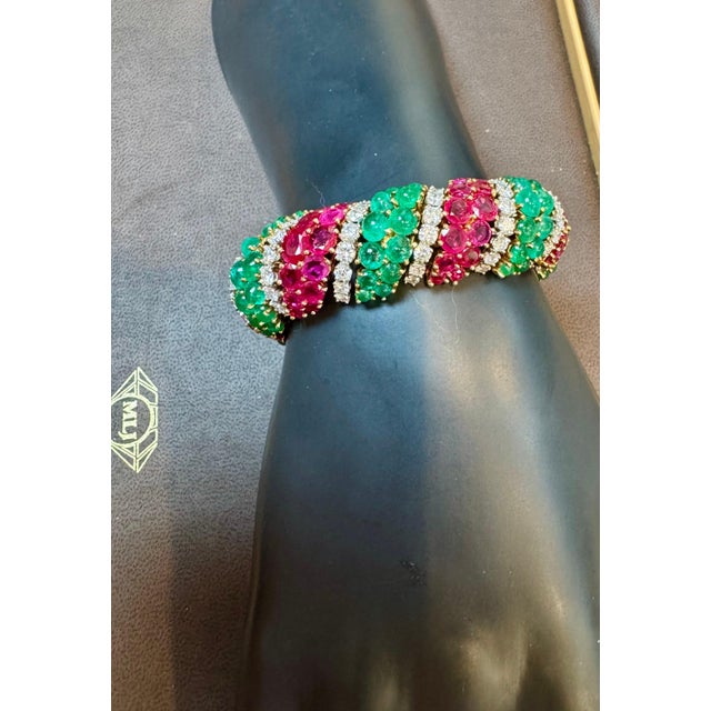 Fine quality vintage 1960's bracelet set with emeralds, rubies, and round brilliant cut diamonds mounted in 18K yellow...