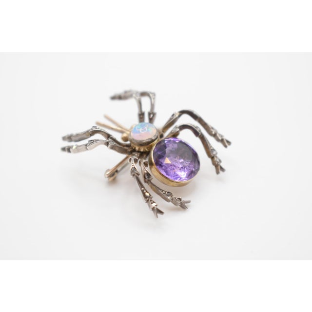 This is a fun opal, amethyst and diamond spider brooch. It is set in yellow gold and silver. The opal is a round cabochon...