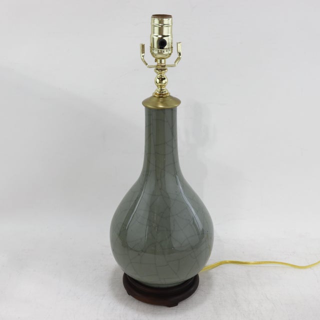 This elegant vintage table lamp features a classic bottle-shaped silhouette crafted from fine porcelain and finished in a...