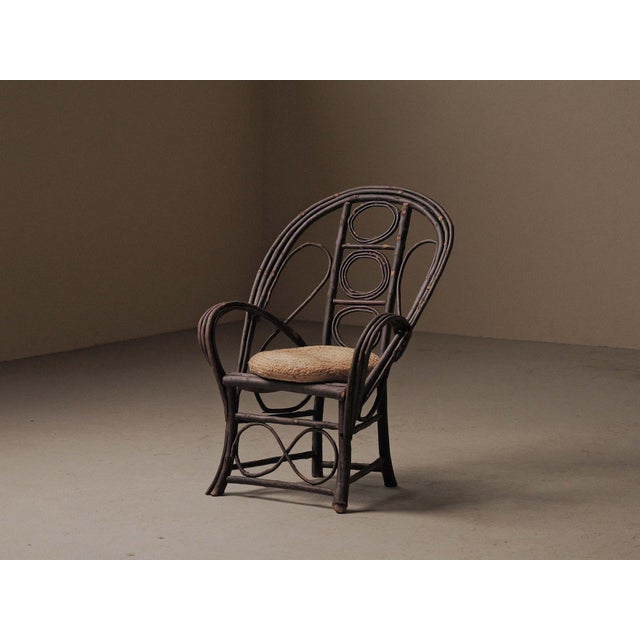 Folk Art armchair made from bent and assembled hazel branches, with a rounded backrest featuring circular and oval motifs...