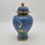 This vintage cloisonné urn features intricate floral designs on a vibrant blue backdrop, accentuated with elegant gold...