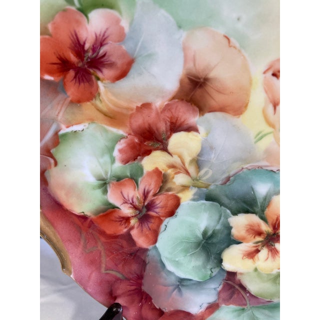 This beautiful plate has hand painted flowers and a gold edge with handles. Made in the early 20th century in Bavaria, it...