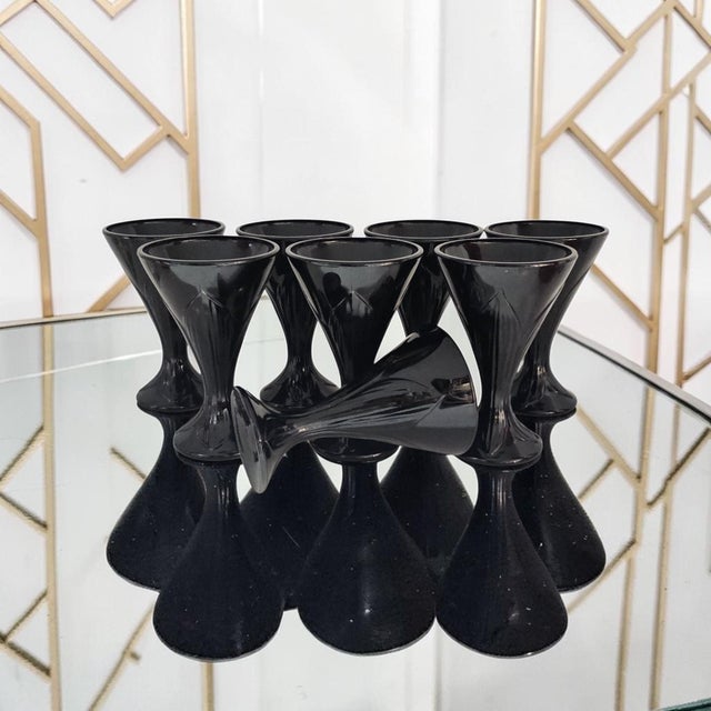 This set of eight La Rochère Fidji black pressed glass goblets was produced in France during the Mid 20th Century, circa...