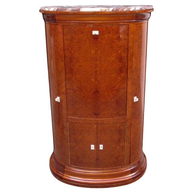 A fine Art Deco bar cabinet. Amboyna with marble top and bone escutcheons. Interior with mirrored surfaces, patinated...