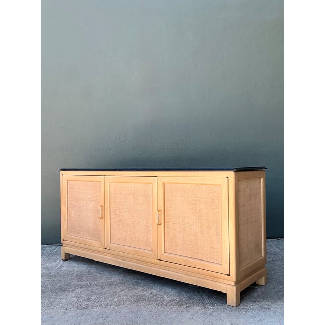 This vintage credenza combines warm-toned wood with a smooth stone top, a material pairing that reflects the clean,...