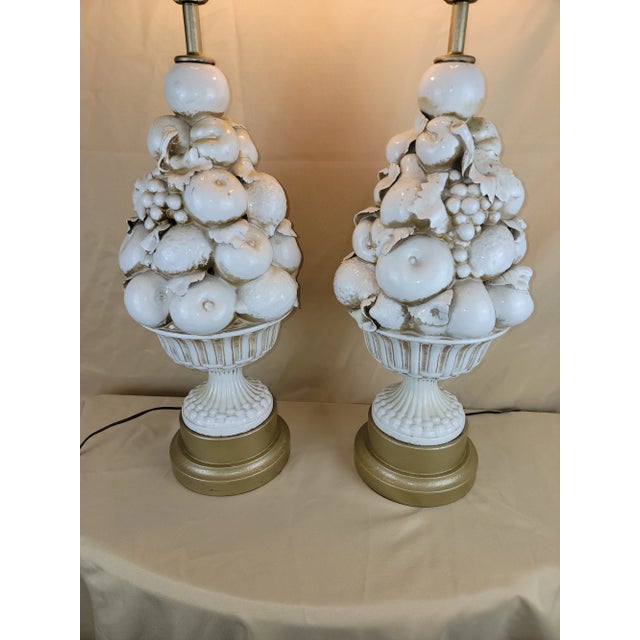 This pair of vintage Italian ceramic table lamps from the 1950s features a unique design with leaves and fruit topiary...