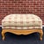 A vintage Baker Furniture French Country ottoman that goes with a bergere chair in tan & red fabric, burnished tacks, and...