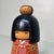 This creative-style (sōsaku) kokeshi doll, crafted by master artist Kazuo Takamizawa, depicts a young girl with a...