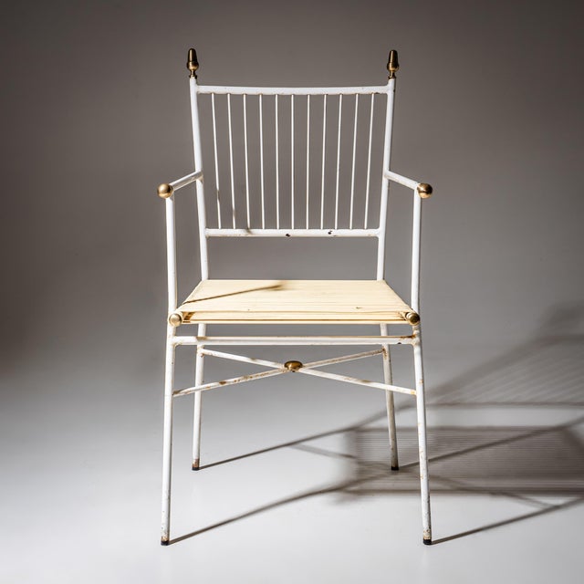 White lacquered Italian armchair designed for terrace or garden use, featuring brass-capped finials and spherical...