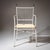 White lacquered Italian armchair designed for terrace or garden use, featuring brass-capped finials and spherical...