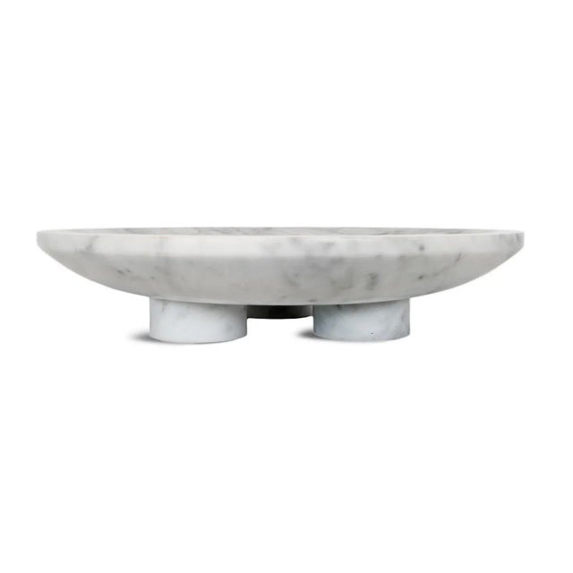 Polished modern solid white marble dish with three feet for elevated display. Each unique in natural marbling and inherent...